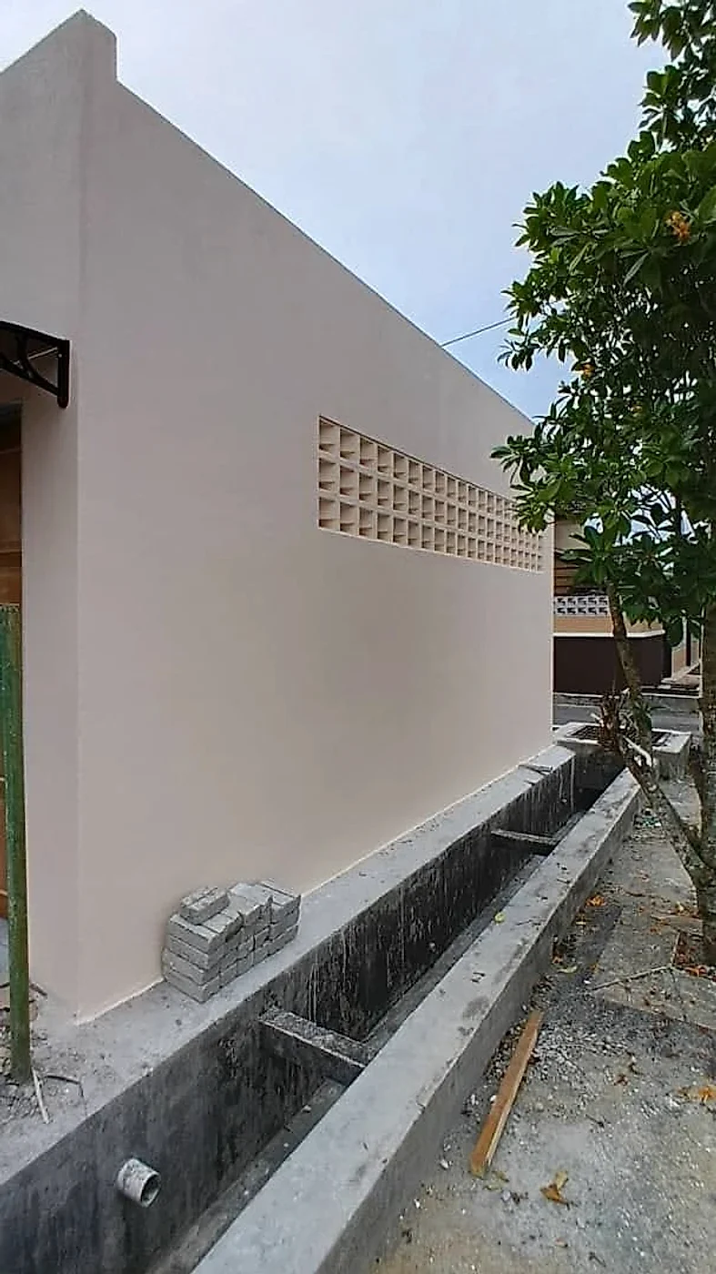 House extension: plastered and painted wall with decorative vent blocks and new drain
