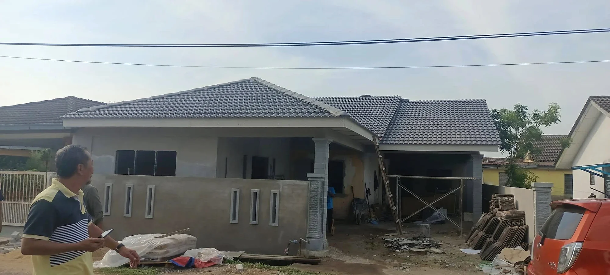 New tiled roof over the extended house, with the walls and front fence plastered