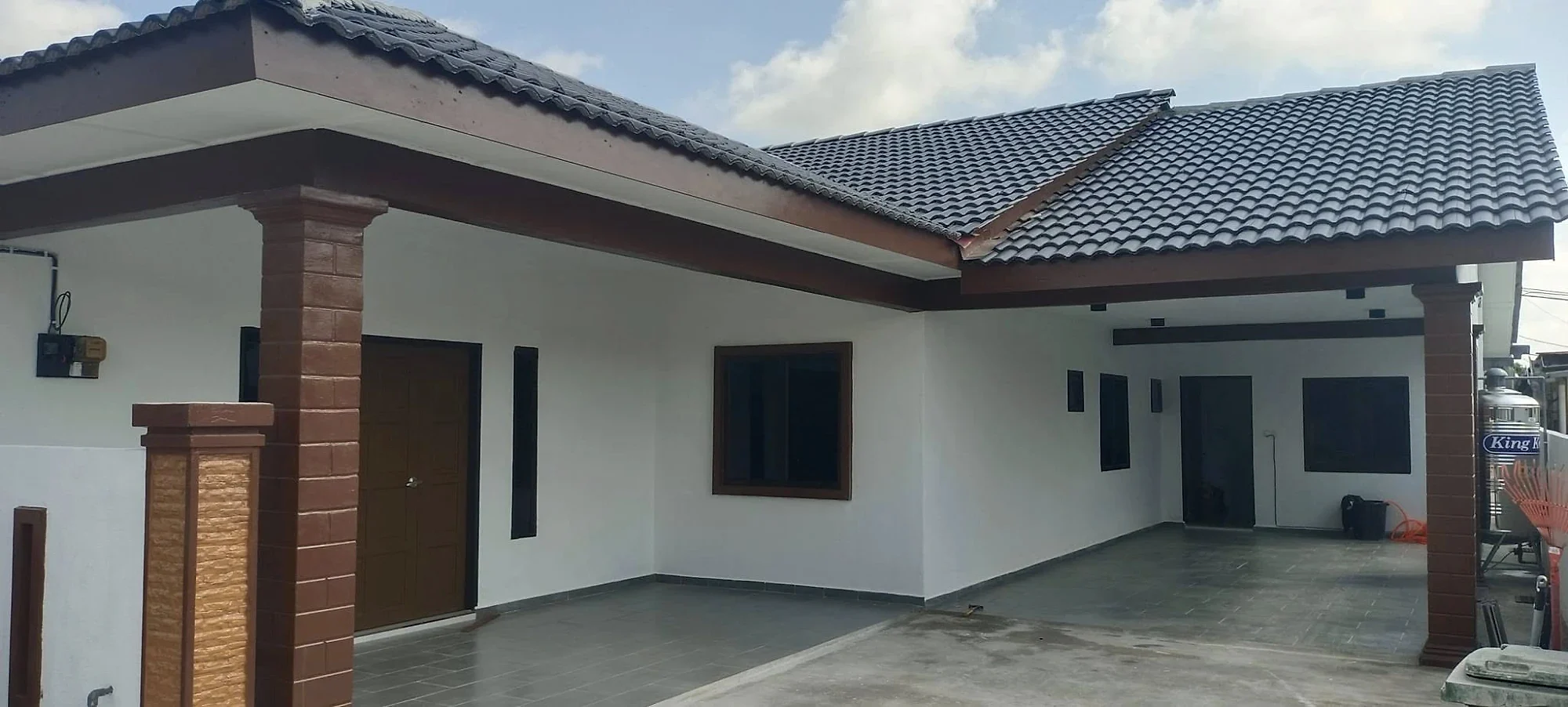 Finished porch and car porch with brown columns and a tiled floor