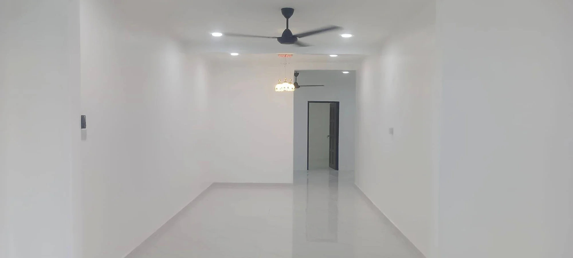 Freshly finished white hall with glossy floor tiles and downlights
