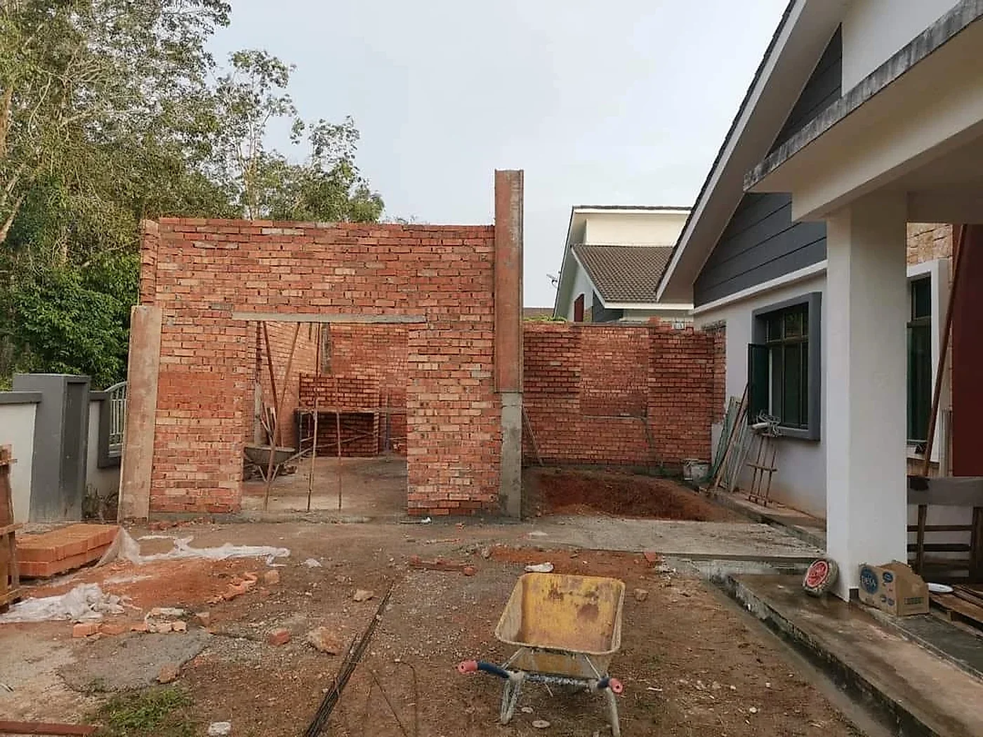 Brick walls of the new wing going up beside the house