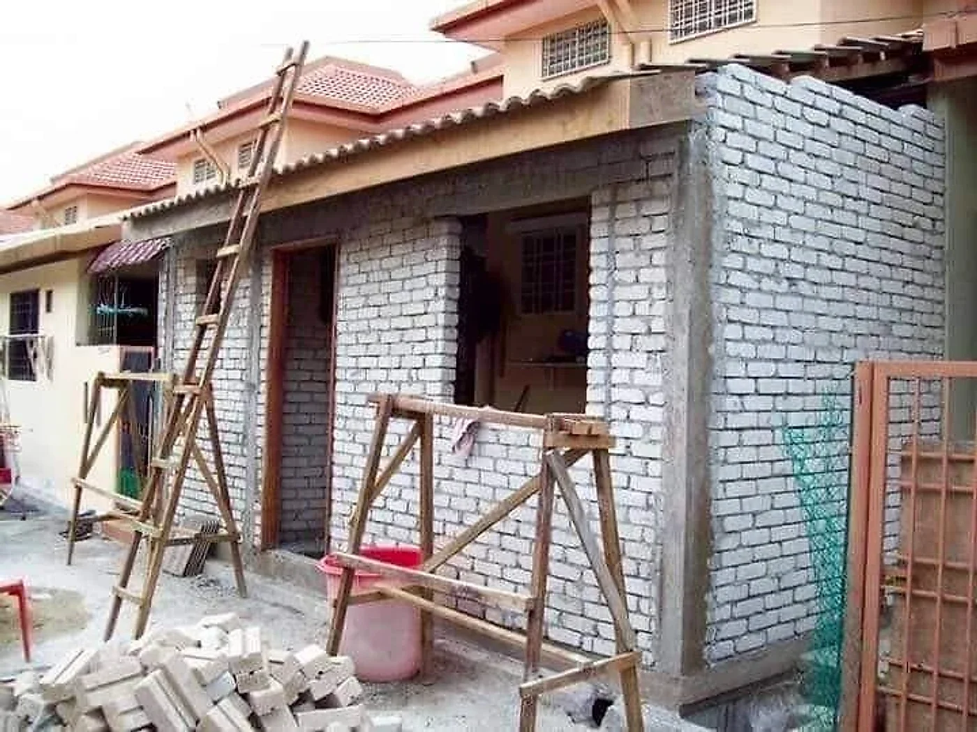 Brick walls of a rear extension with door and window openings under a new roof
