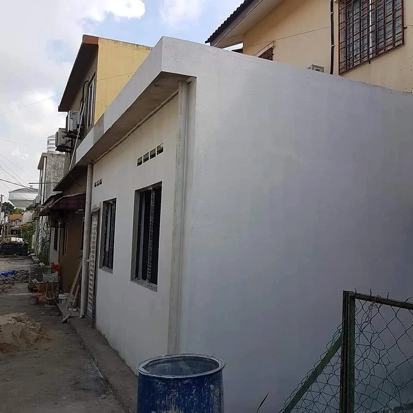 Finished extension painted white along a back lane