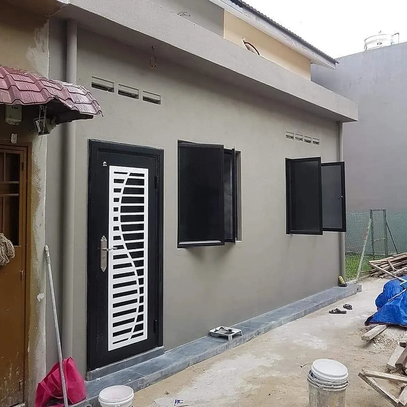 Extension painted grey with a new security door and black framed windows