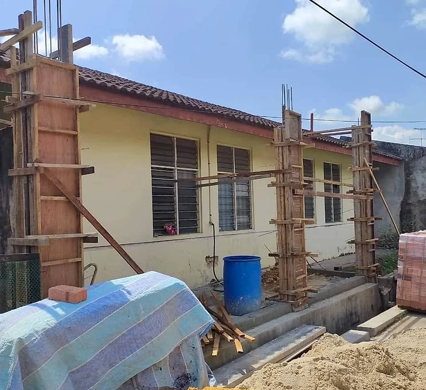 Timber formwork for the new kitchen block's columns beside the house
