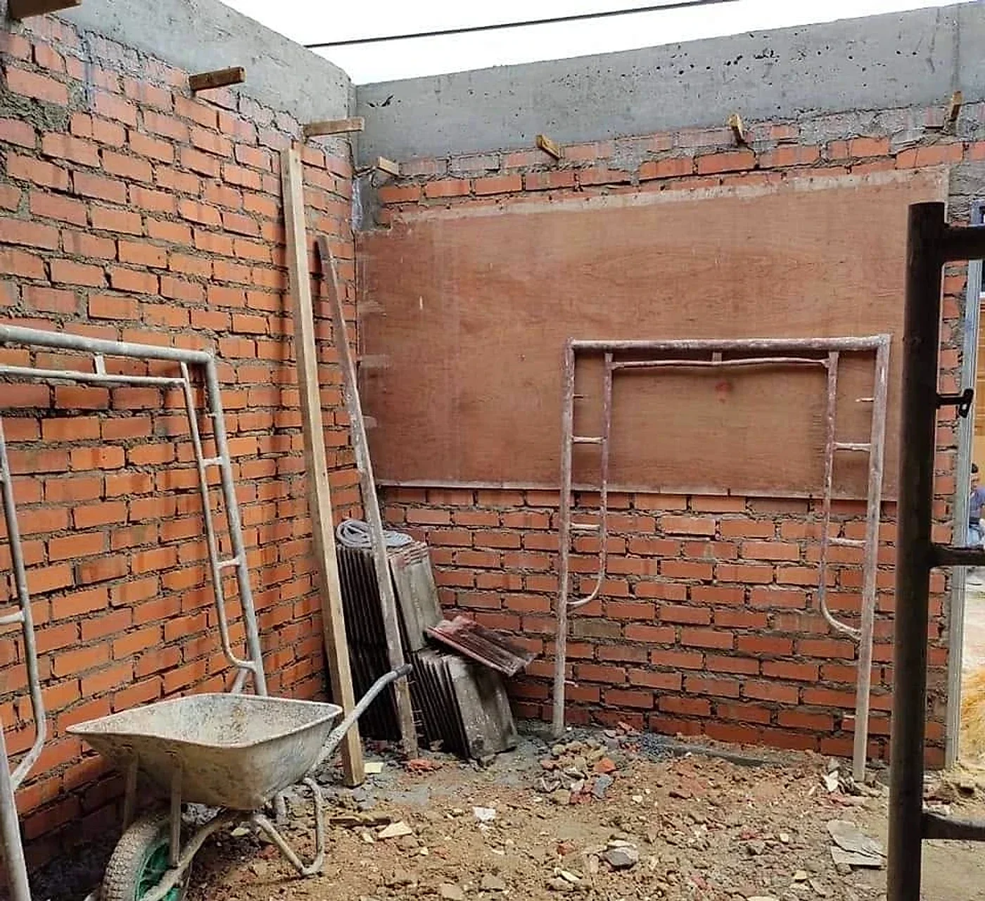 Brick walls of the new kitchen going up under a concrete beam