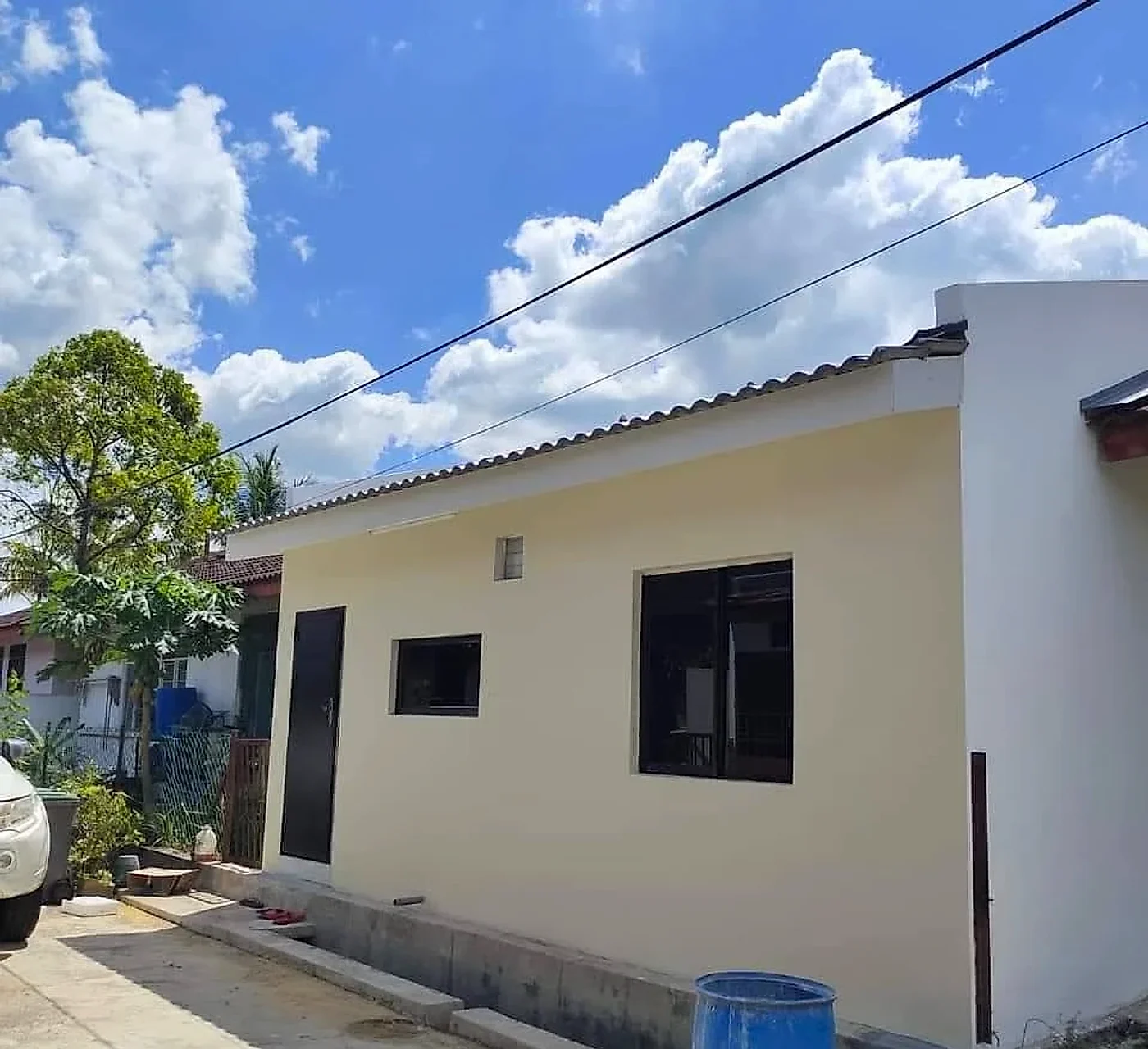 New kitchen block at the side of the house, painted cream with black windows and door