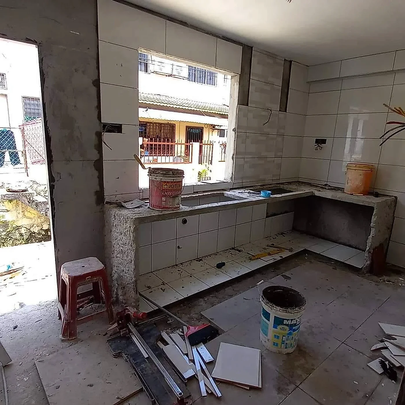 Concrete kitchen counter being rebuilt with wall and floor tiling under way