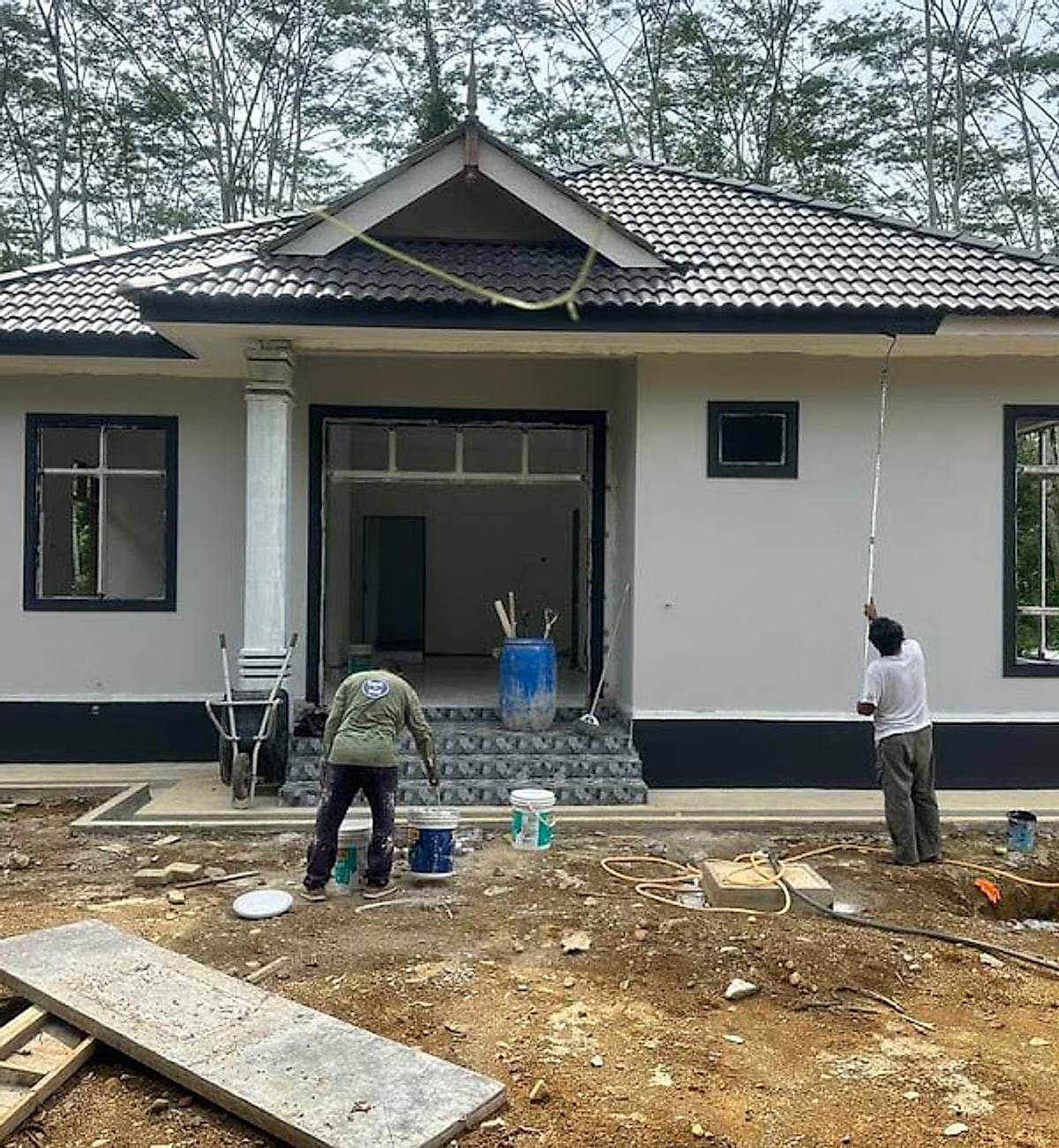 Crew finishing the front of a gabled bungalow