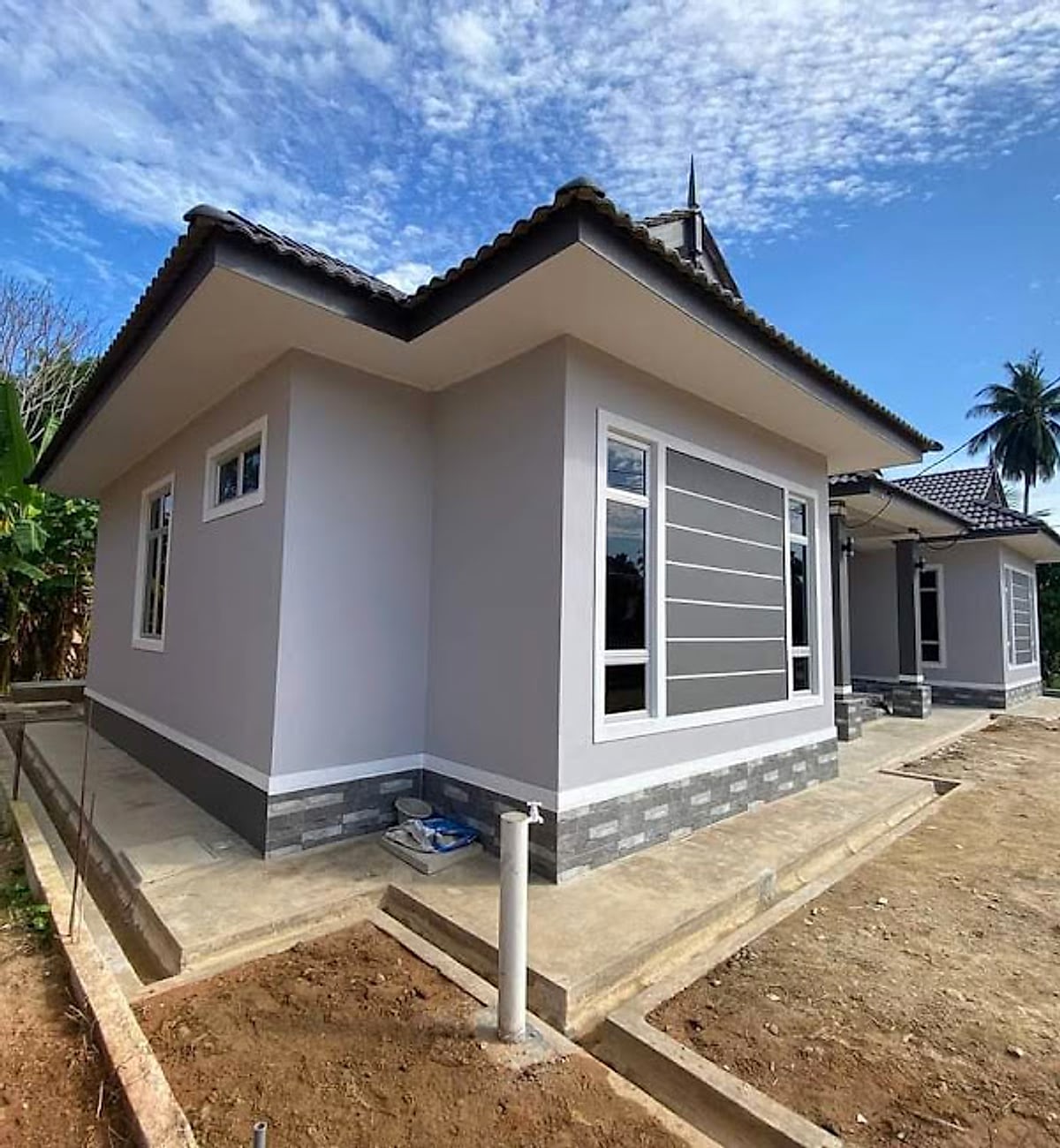 Bungalow corner with stone-clad plinth and white window frames