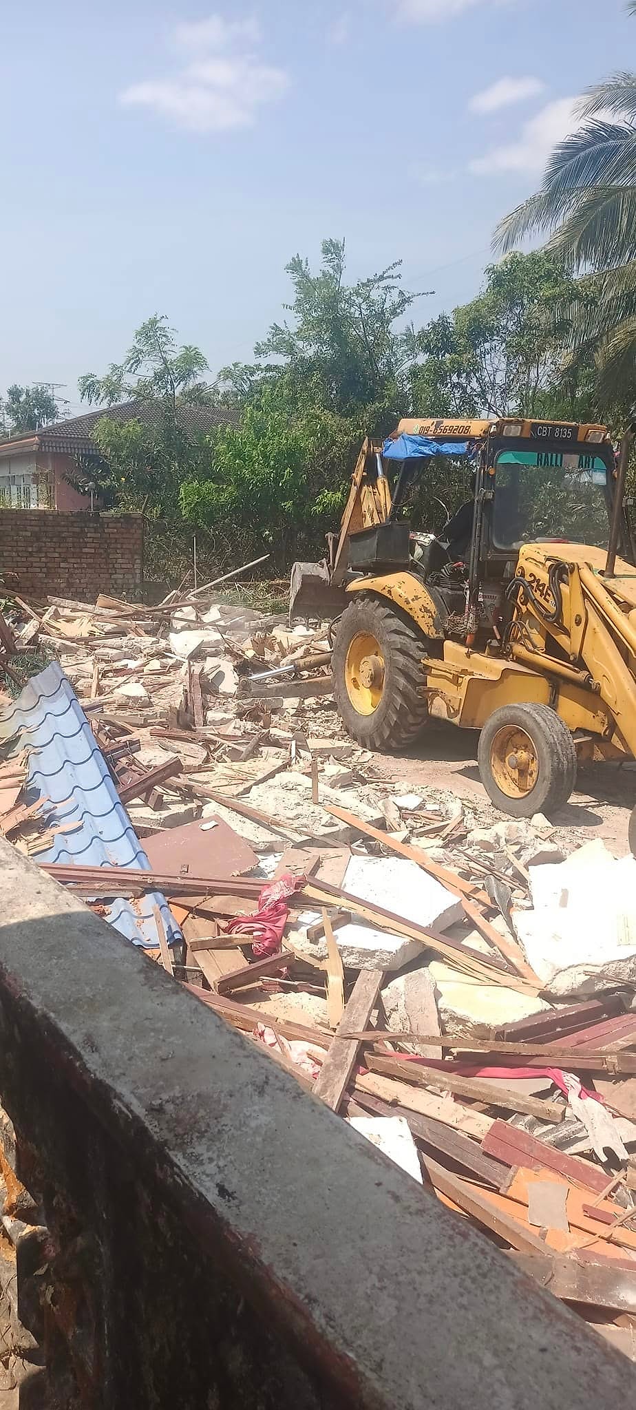 Backhoe clearing the old house before a new build