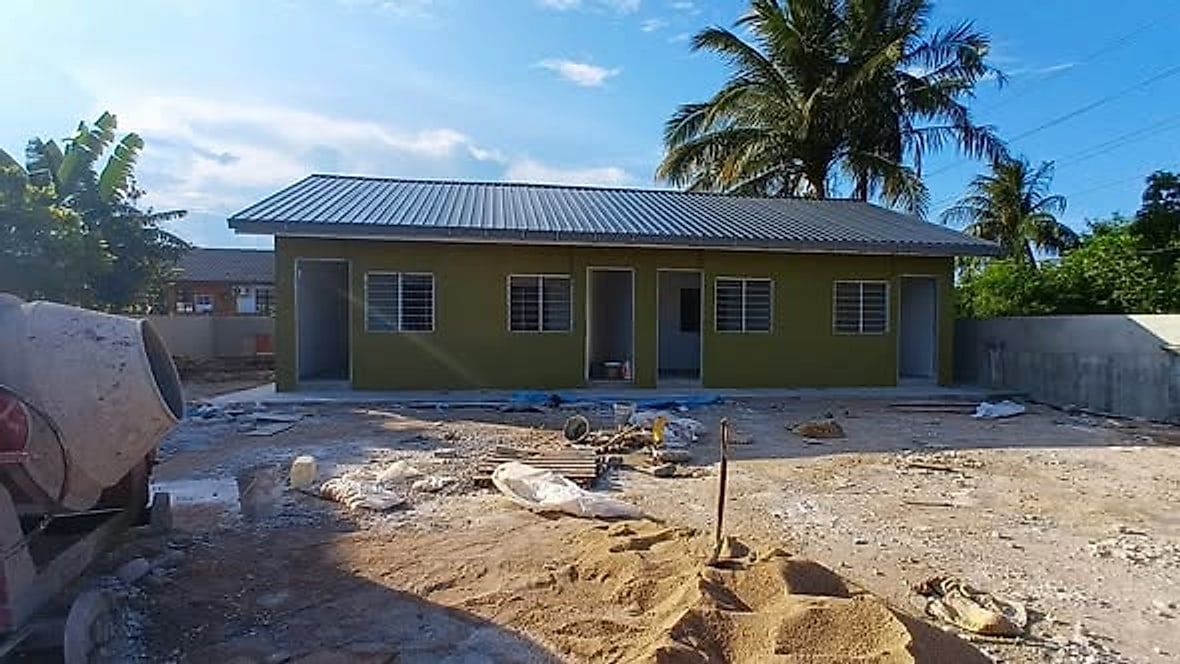 Finished row house painted green with a new metal roof