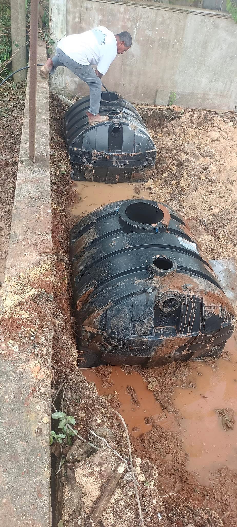 Two underground water tanks being installed beside the boundary wall