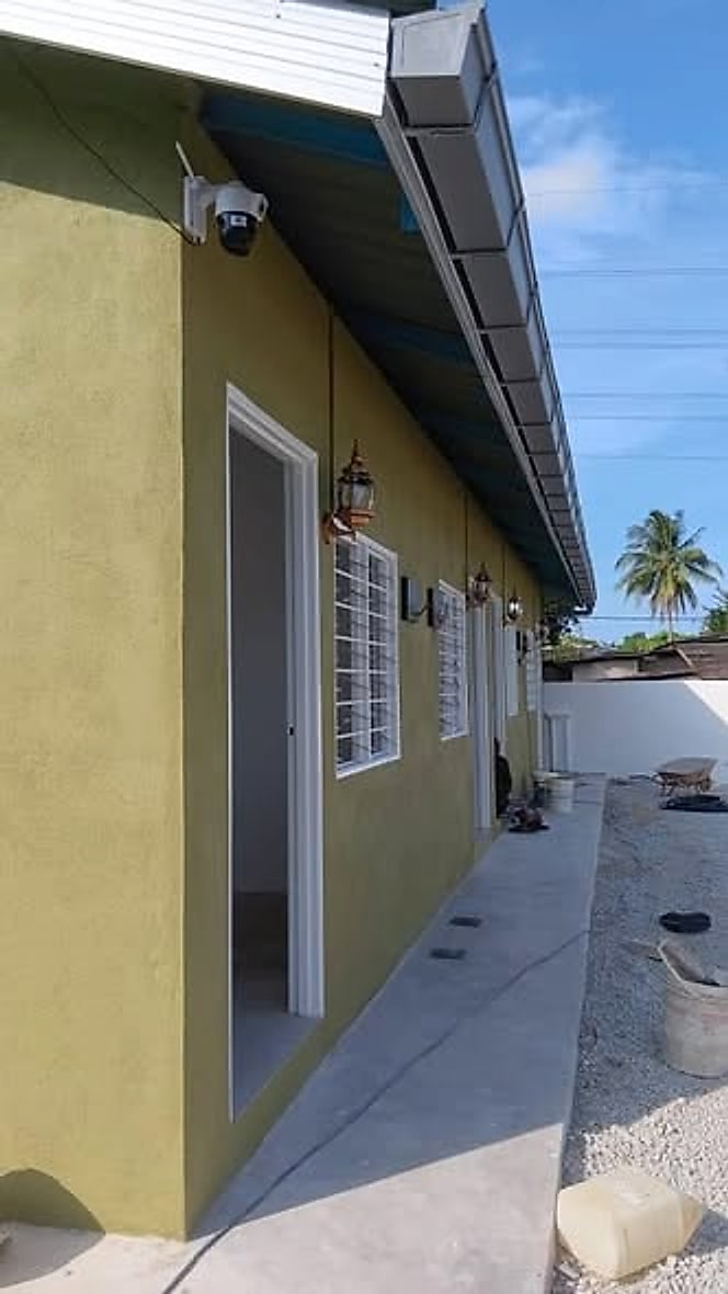 Side walkway of the finished row house with wall lamps and gutter