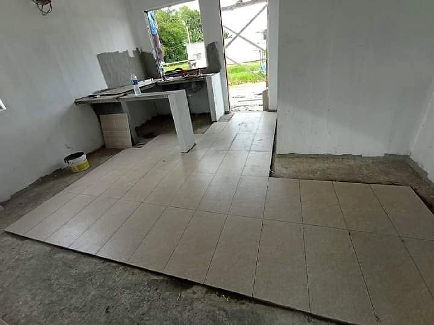 Floor tiles being laid in the kitchen and living area