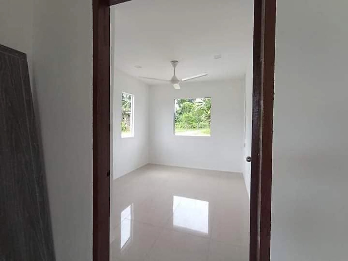 Finished bedroom with glossy floor tiles and a ceiling fan