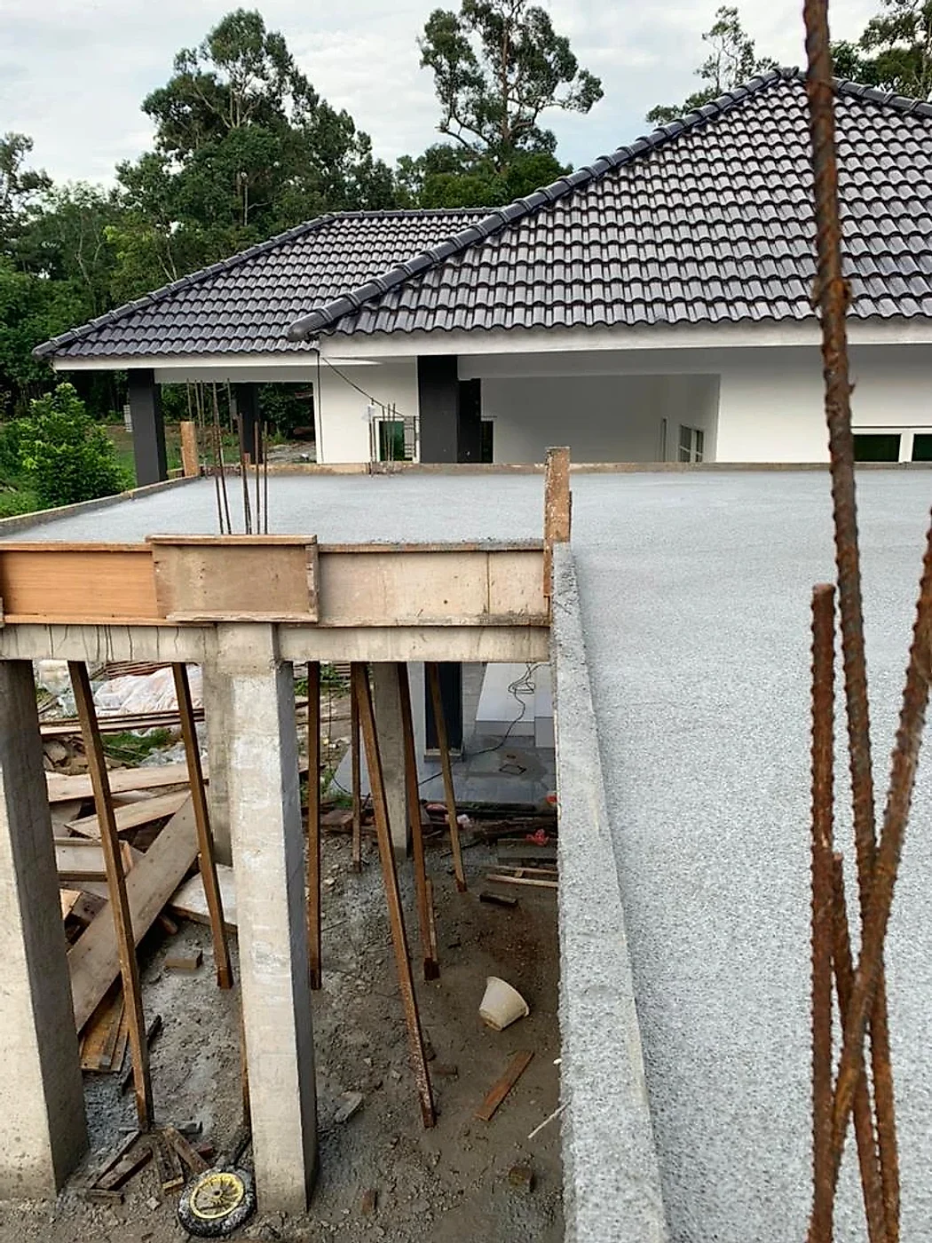 Suspended slab on timber props beside the finished main house