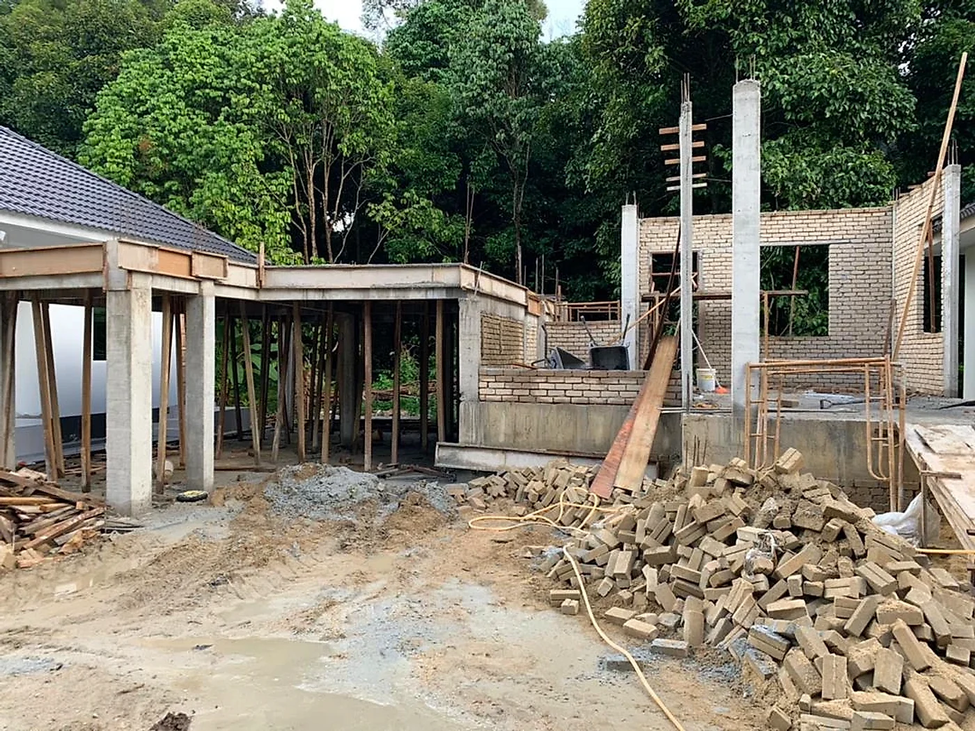 Concrete columns, propped slab and brick walls going up