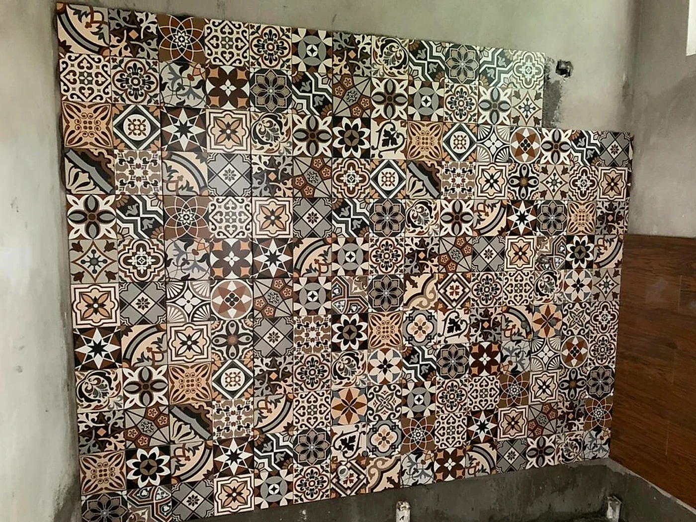 Patterned feature tiles going up on a bathroom wall