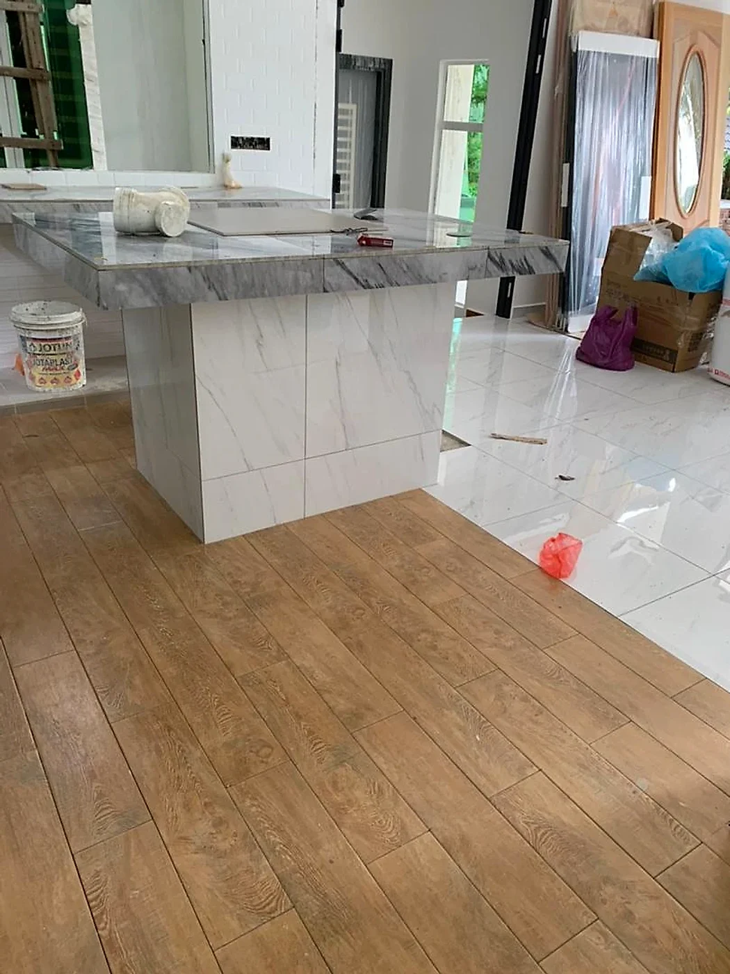 Kitchen island tiled in marble-look tiles over a wood-look floor