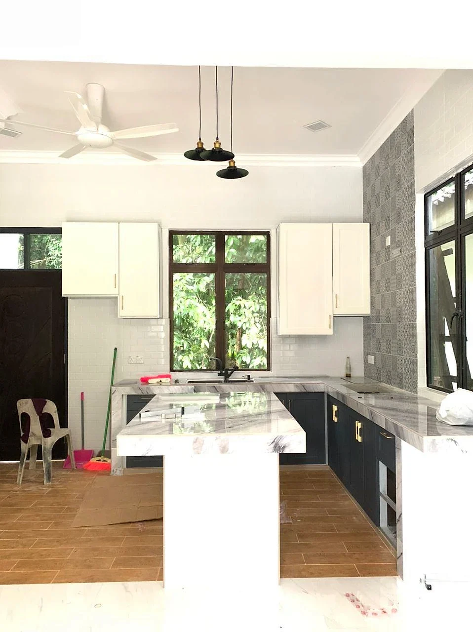 Finished kitchen with white and navy cabinets, marble-look counter and island