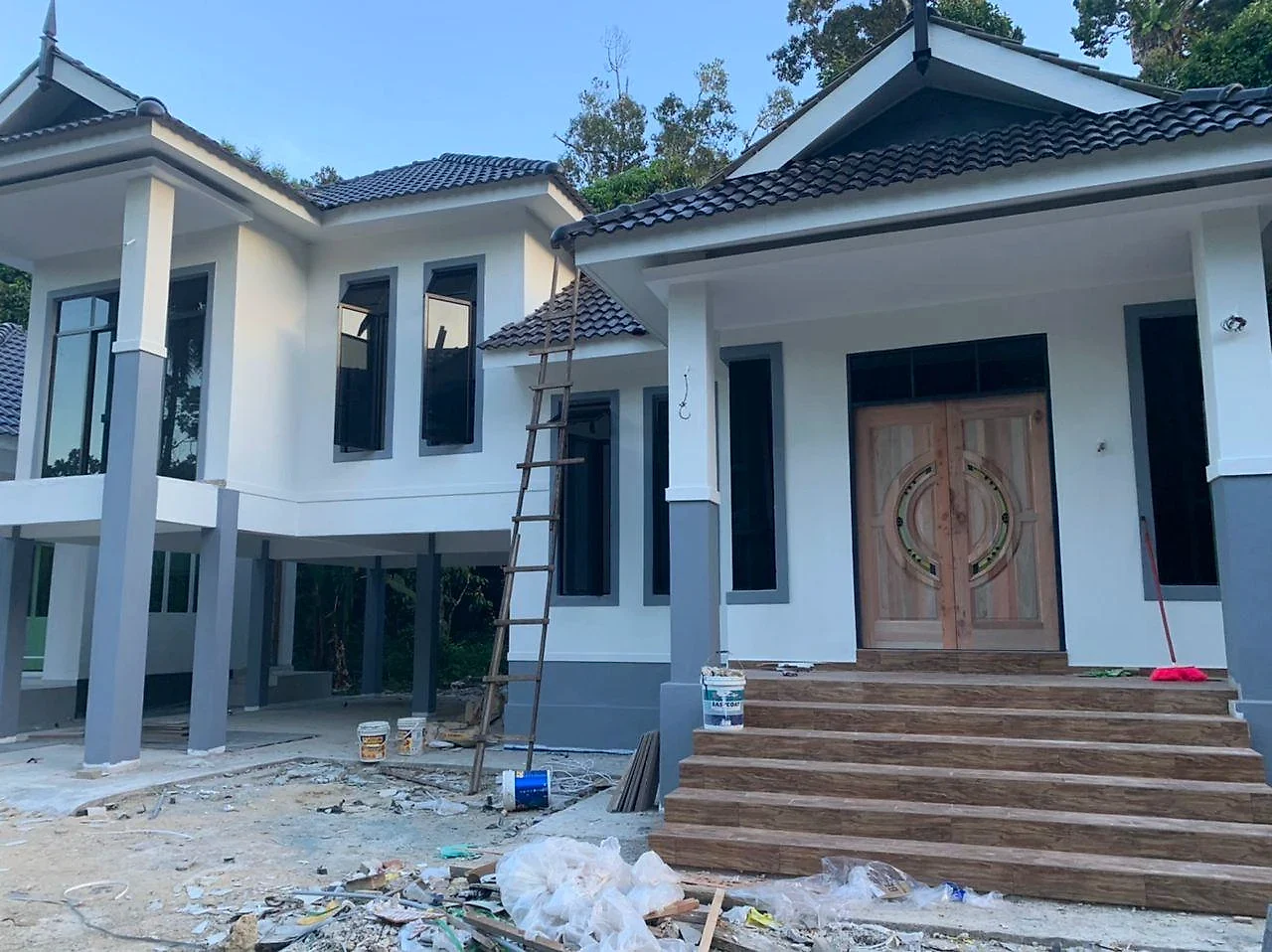 The finished bungalow painted white and grey with timber double doors