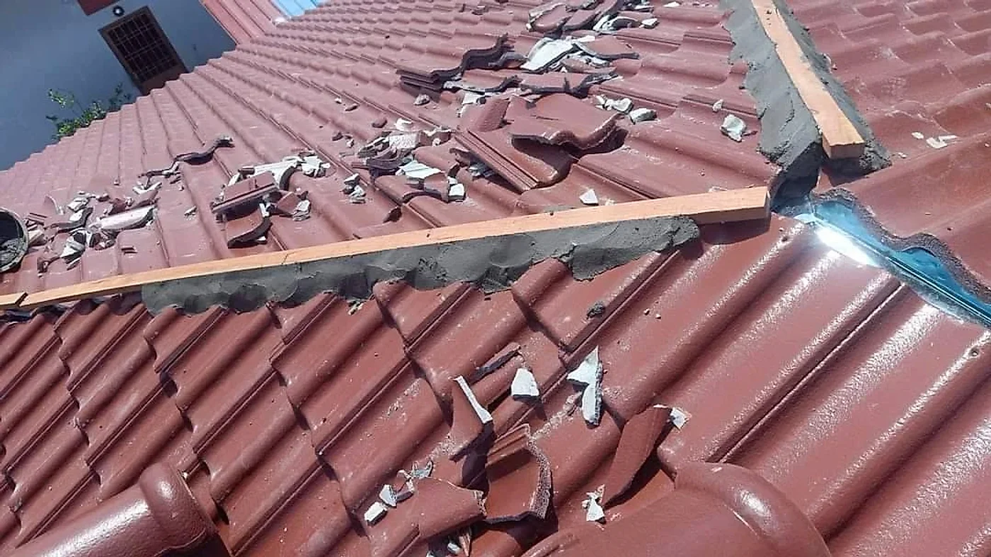 Ridge line being set in mortar along a timber guide on the new tiles