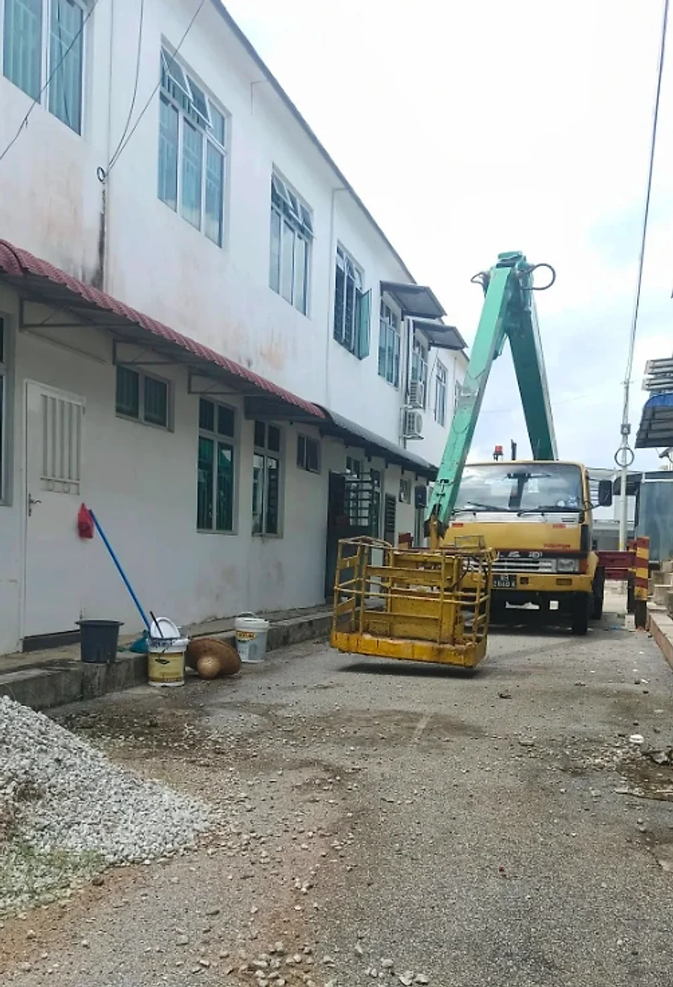 Sky lift truck set up to reach the roof slab of a two-storey building