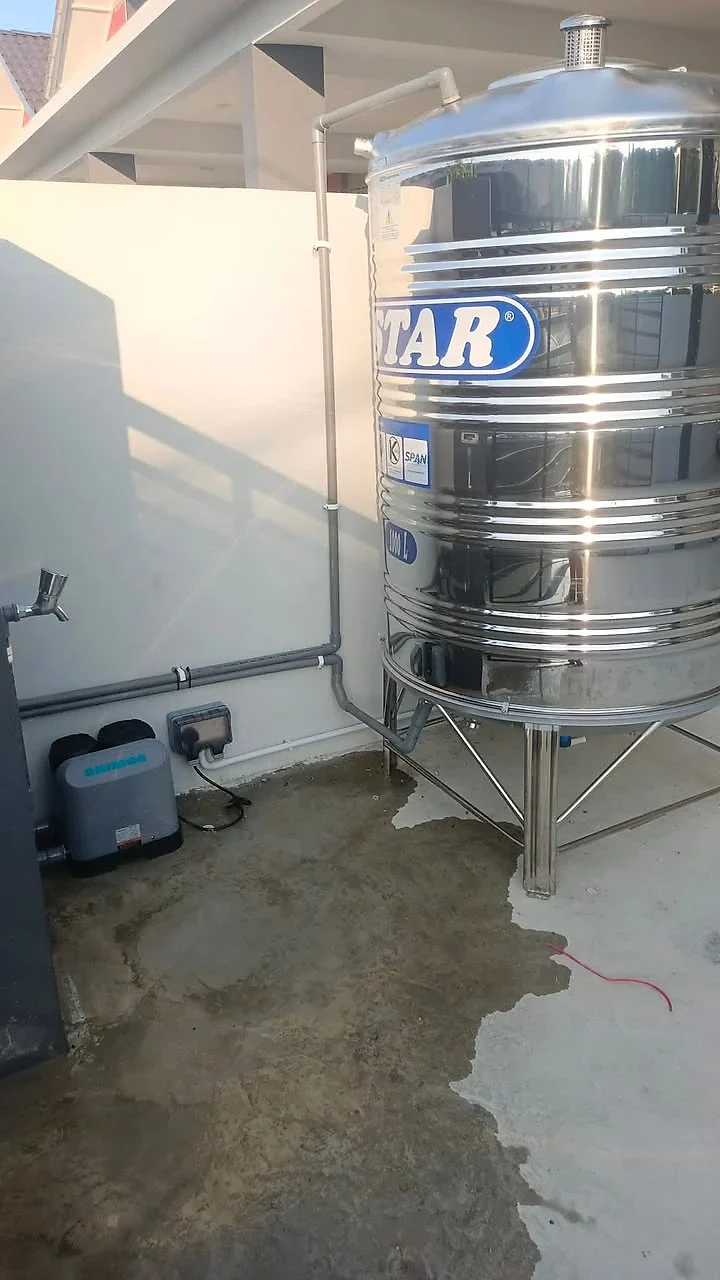 Stainless steel tank beside a wall with pump and neat piping